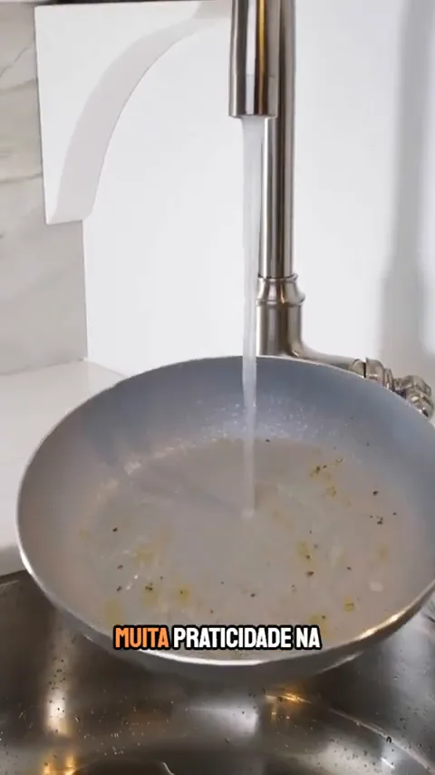 Frigideira cerâmica sendo lavada com água corrente na pia