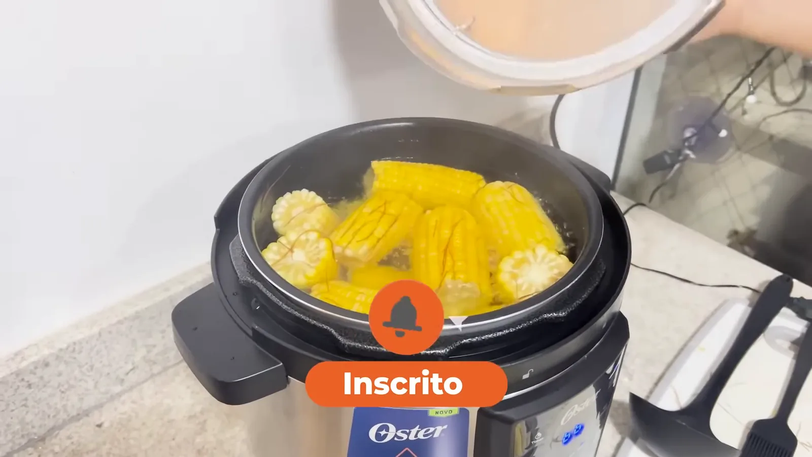 Panela de pressão elétrica Oster com milho fervendo em vapor intenso