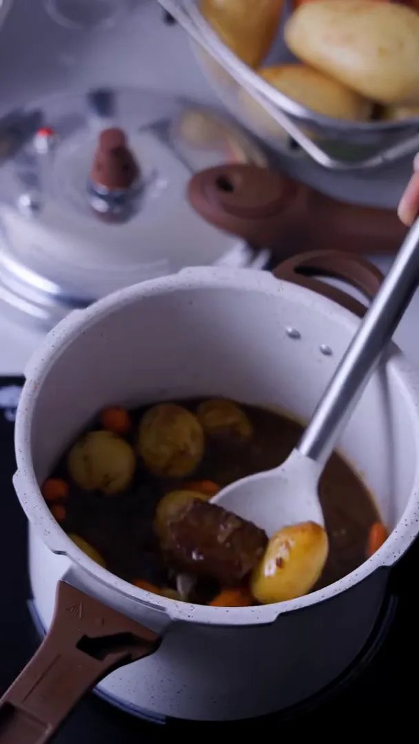 Retirando carne e legumes cozidos de dentro da panela Brinox
