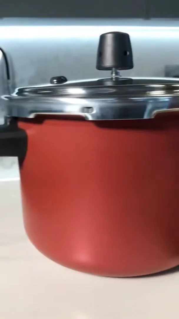 Panela de pressão fechada em acabamento vermelho sobre a bancada
