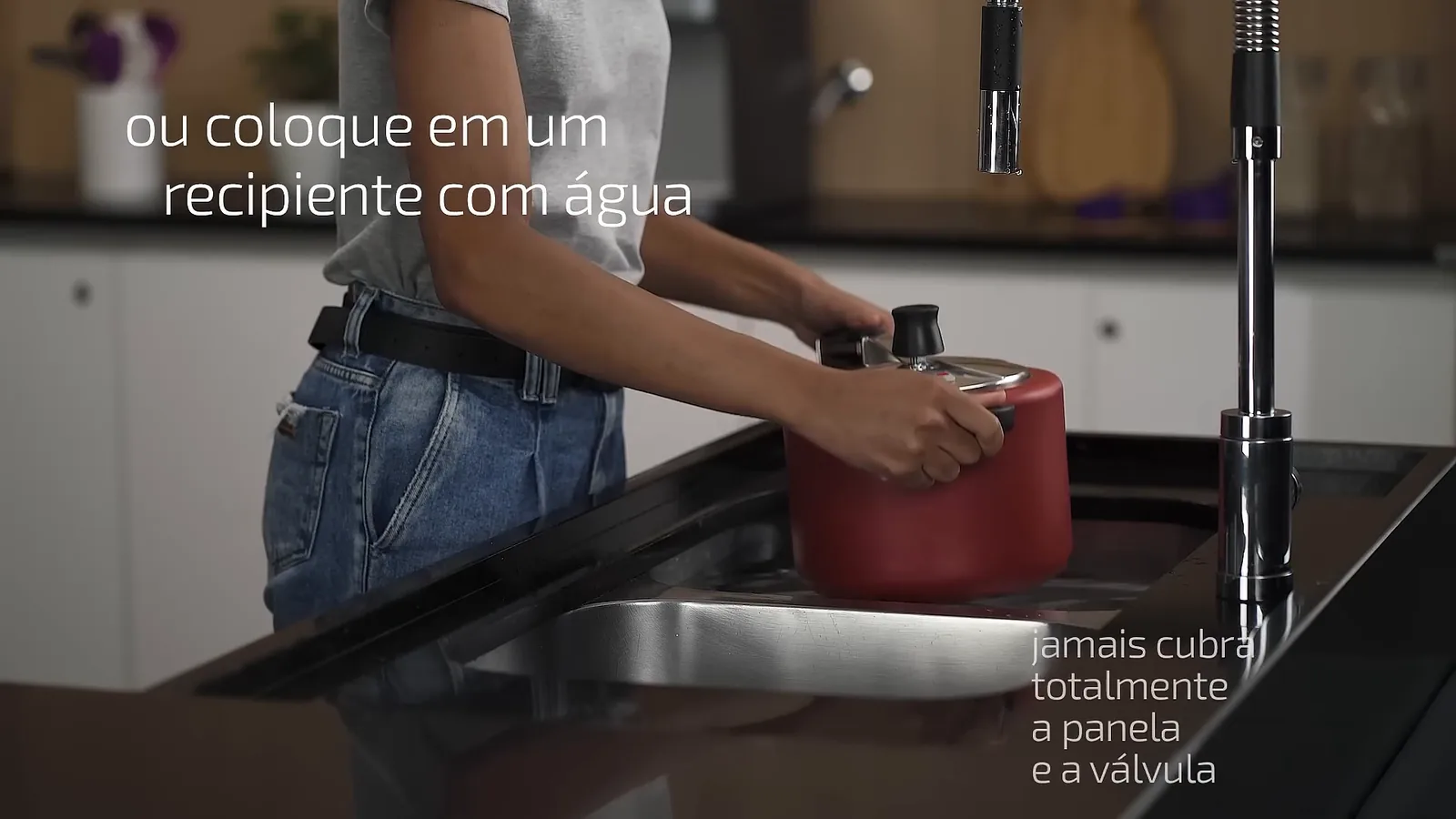 Panela de pressão colocada na água da pia para resfriamento