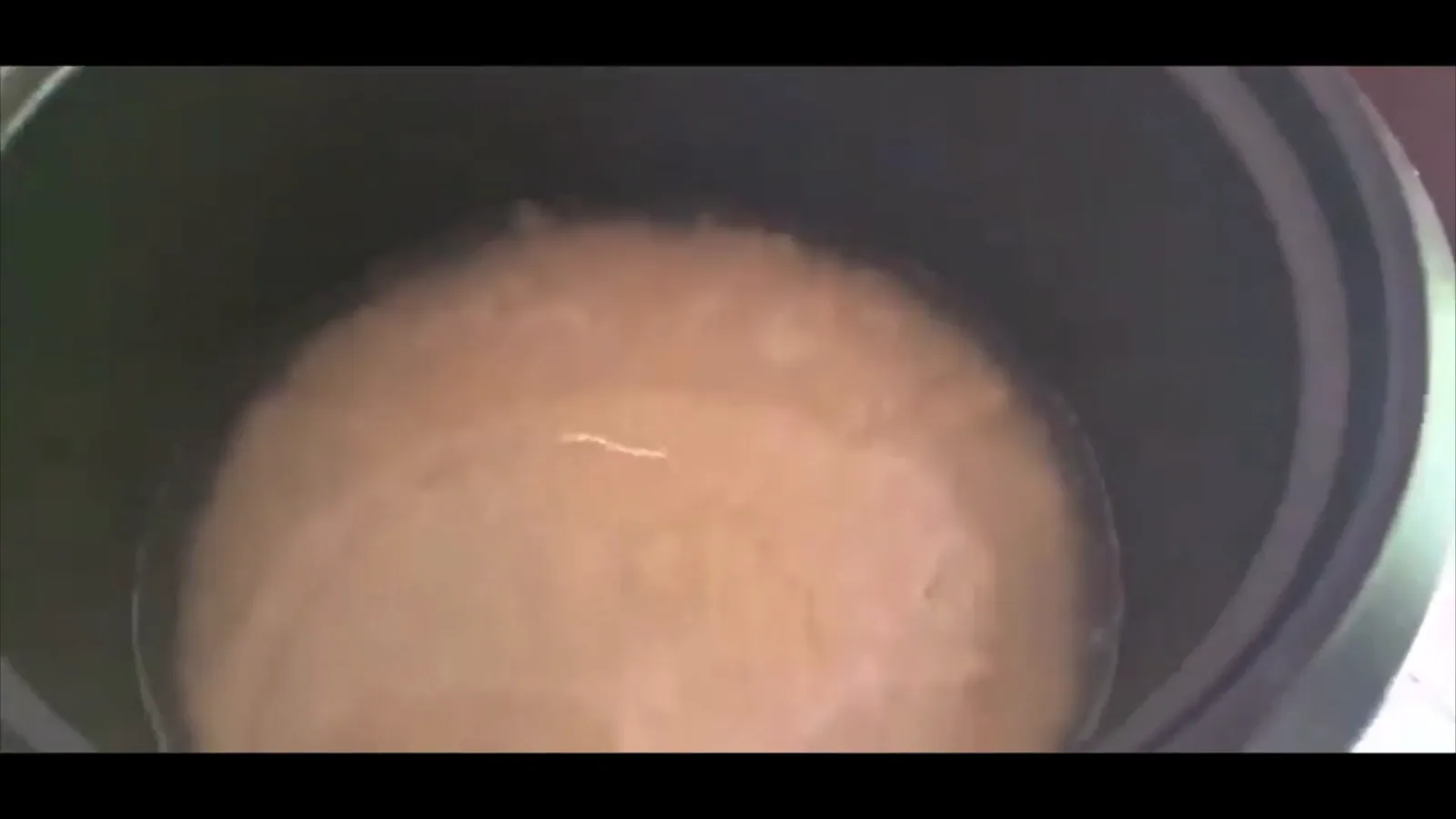 Arroz em cozimento dentro da panela elétrica aberta durante o preparo