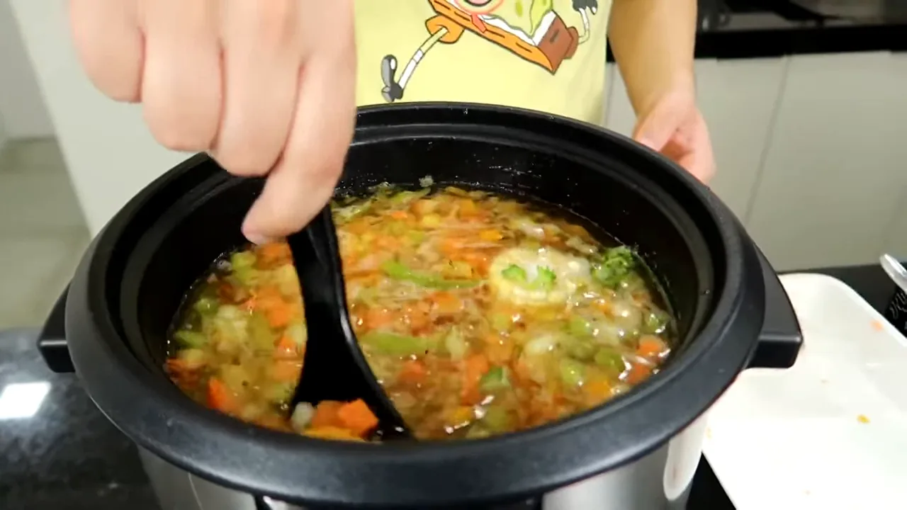 Espátula misturando legumes durante o cozimento na panela elétrica Electrolux