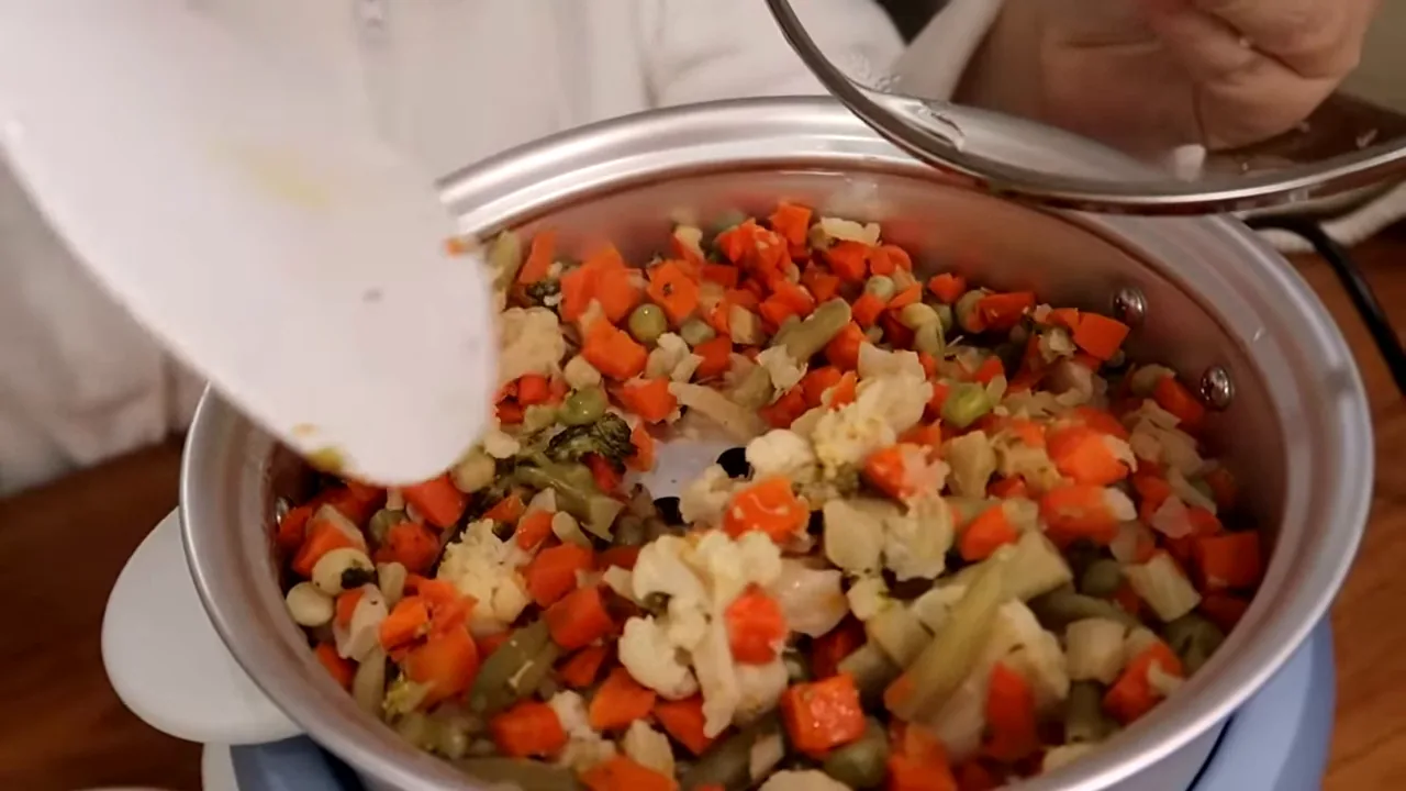 Legumes sendo misturados após cozimento no vapor na panela elétrica