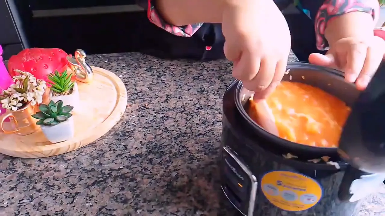 Adicionando água aos ingredientes na panela elétrica de arroz