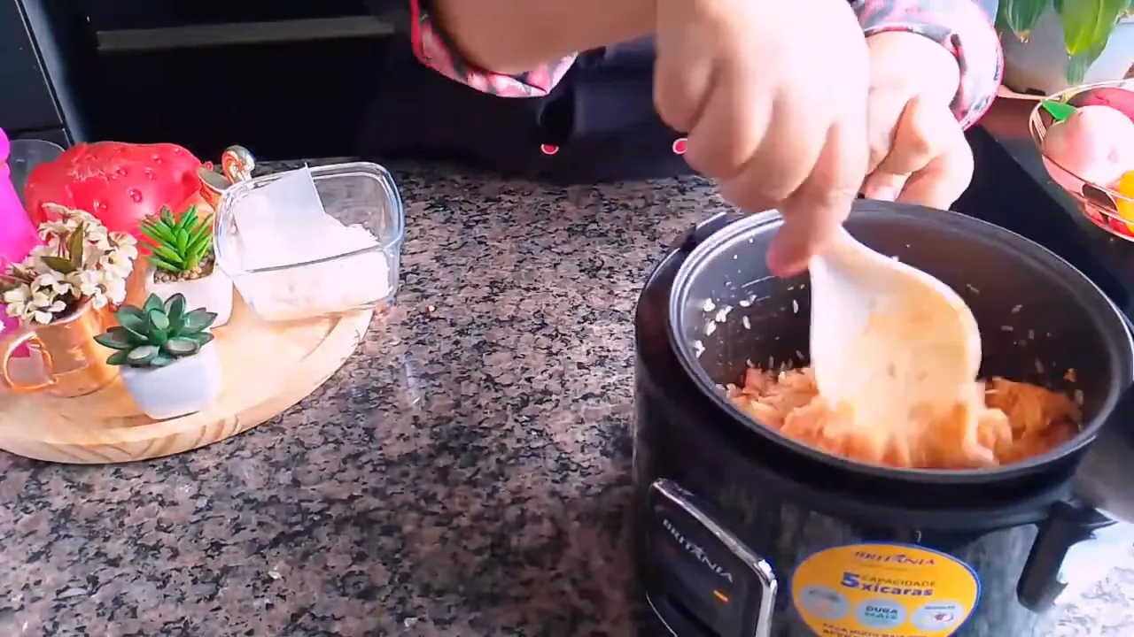 Refogando arroz com frango na panela elétrica Britânia