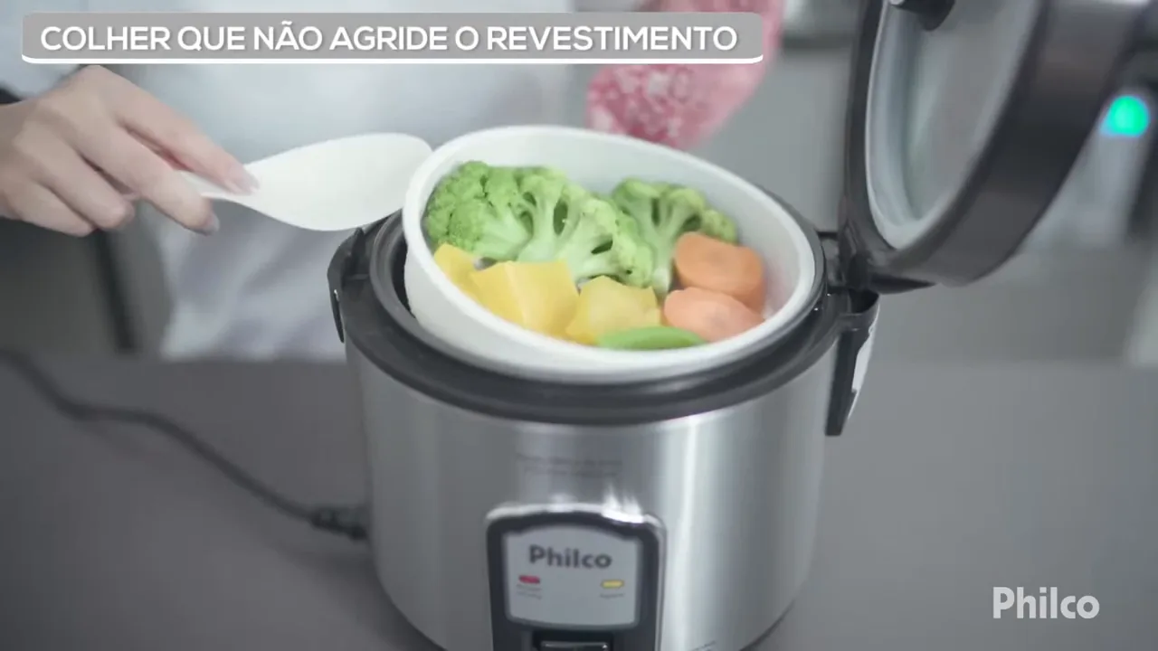 Retirada do cesto de vapor com legumes sobre o arroz cozido