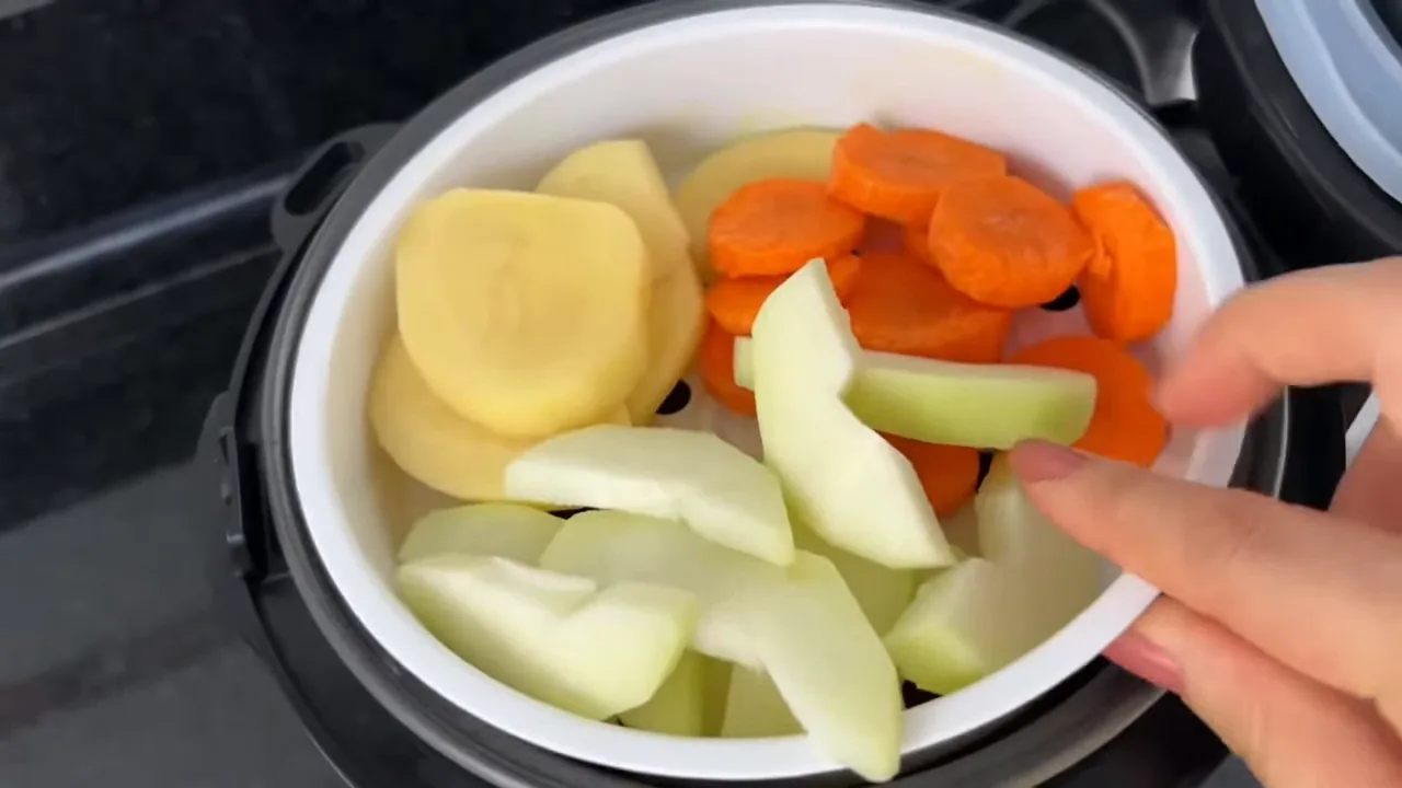 Encaixe da bandeja com legumes na panela elétrica de arroz