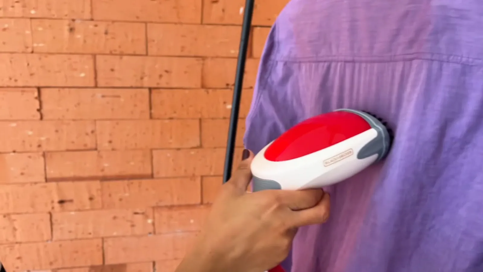 Vaporizador portátil Black+Decker alisando camisa de tecido na vertical