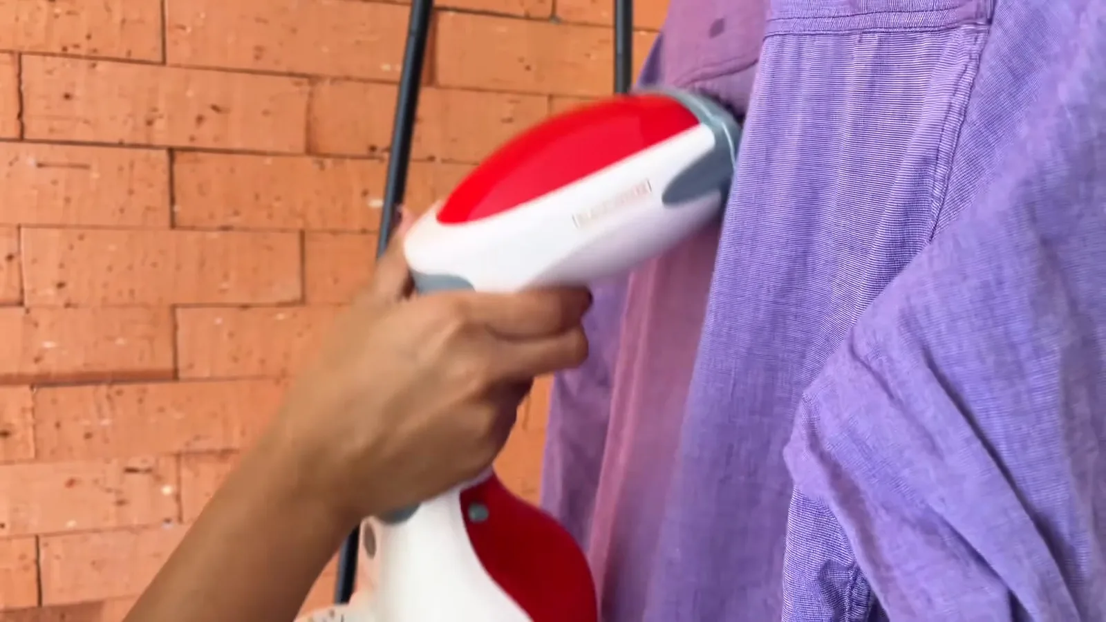 Passadeira a vapor Black+Decker desamassando camisa com jato contínuo