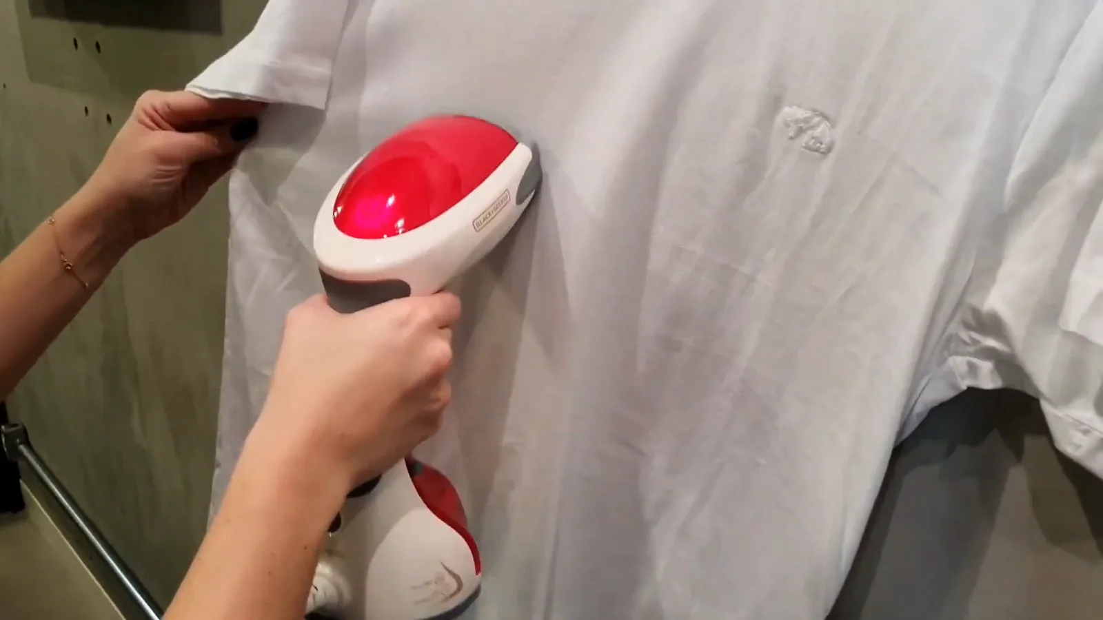 Passadeira a vapor Black+Decker alisando o tecido de camiseta