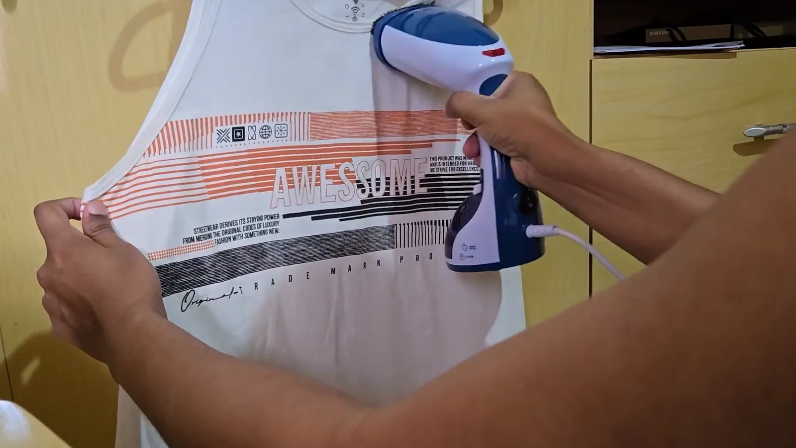 Passadeira a vapor Mondial desamassando camiseta pendurada no cabide