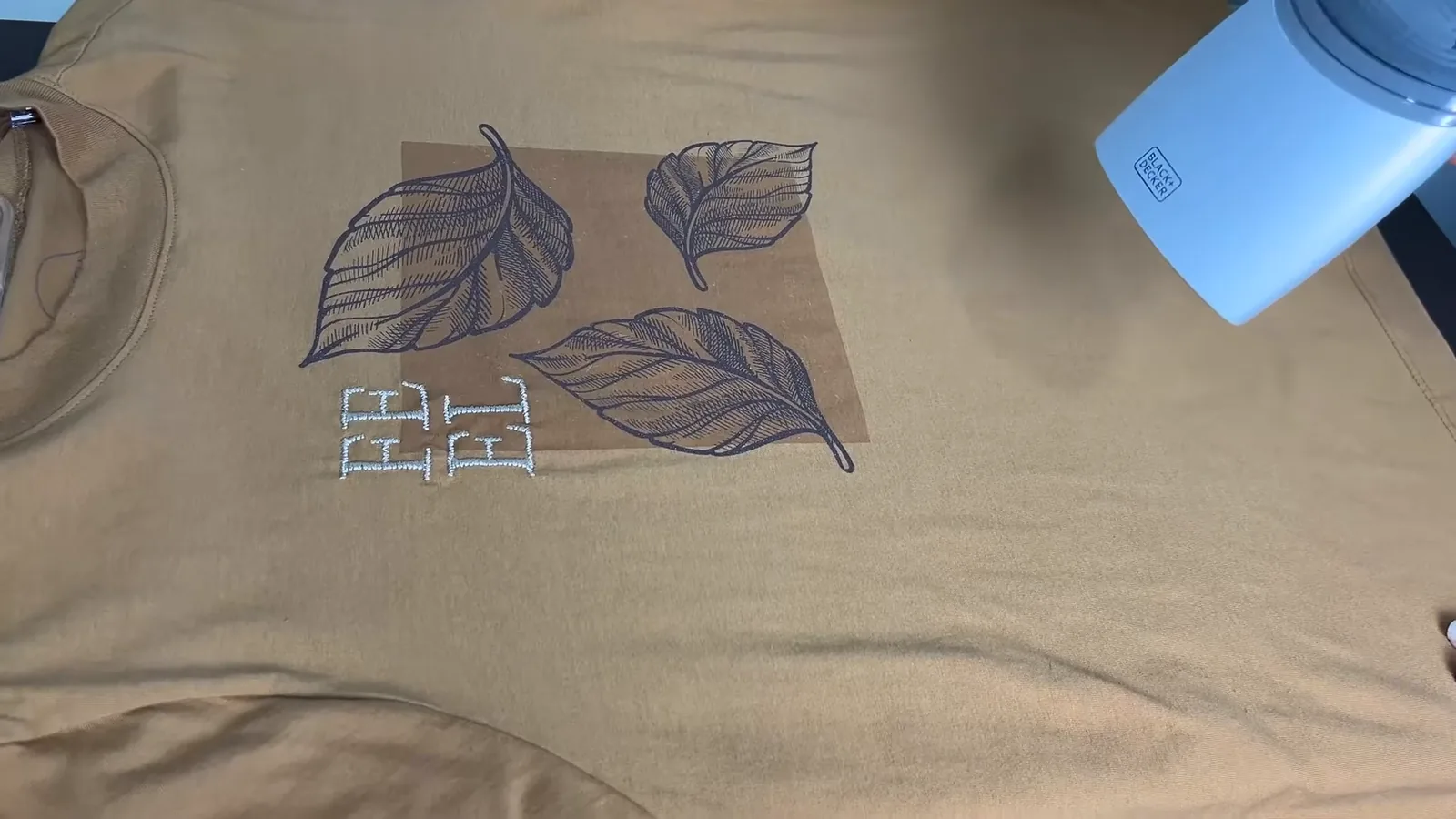 Passadeira a vapor sendo utilizada na horizontal sobre camiseta amarela