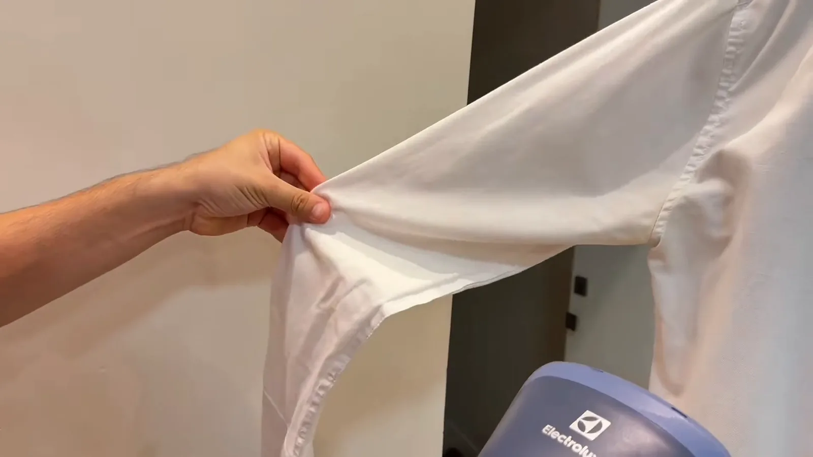 Bocal a vapor deslizando sobre o tecido da manga comprida