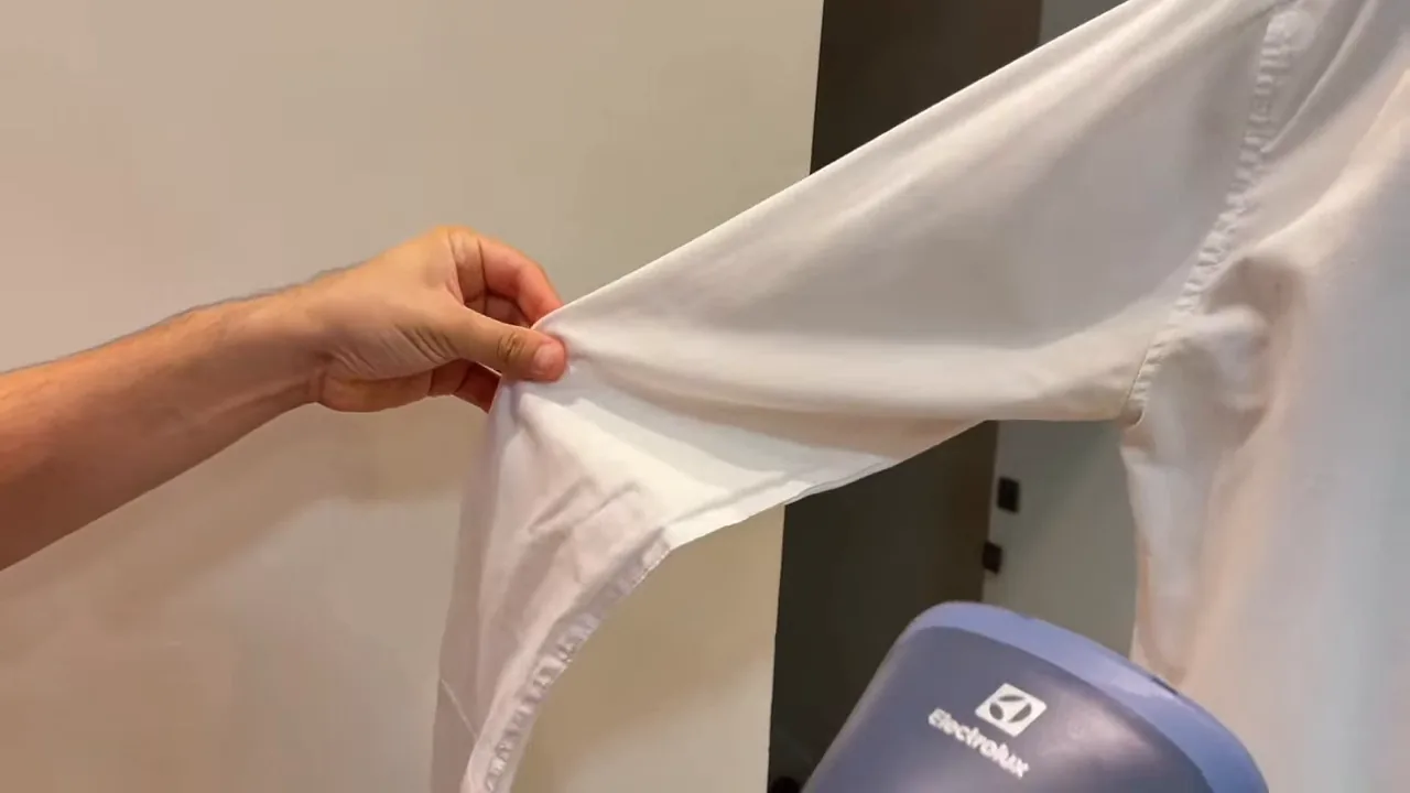 Vaporizador em funcionamento passando a manga de camisa social