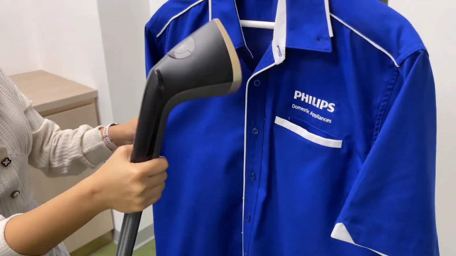 Bocal a vapor alisando o colarinho de uma camisa pendurada