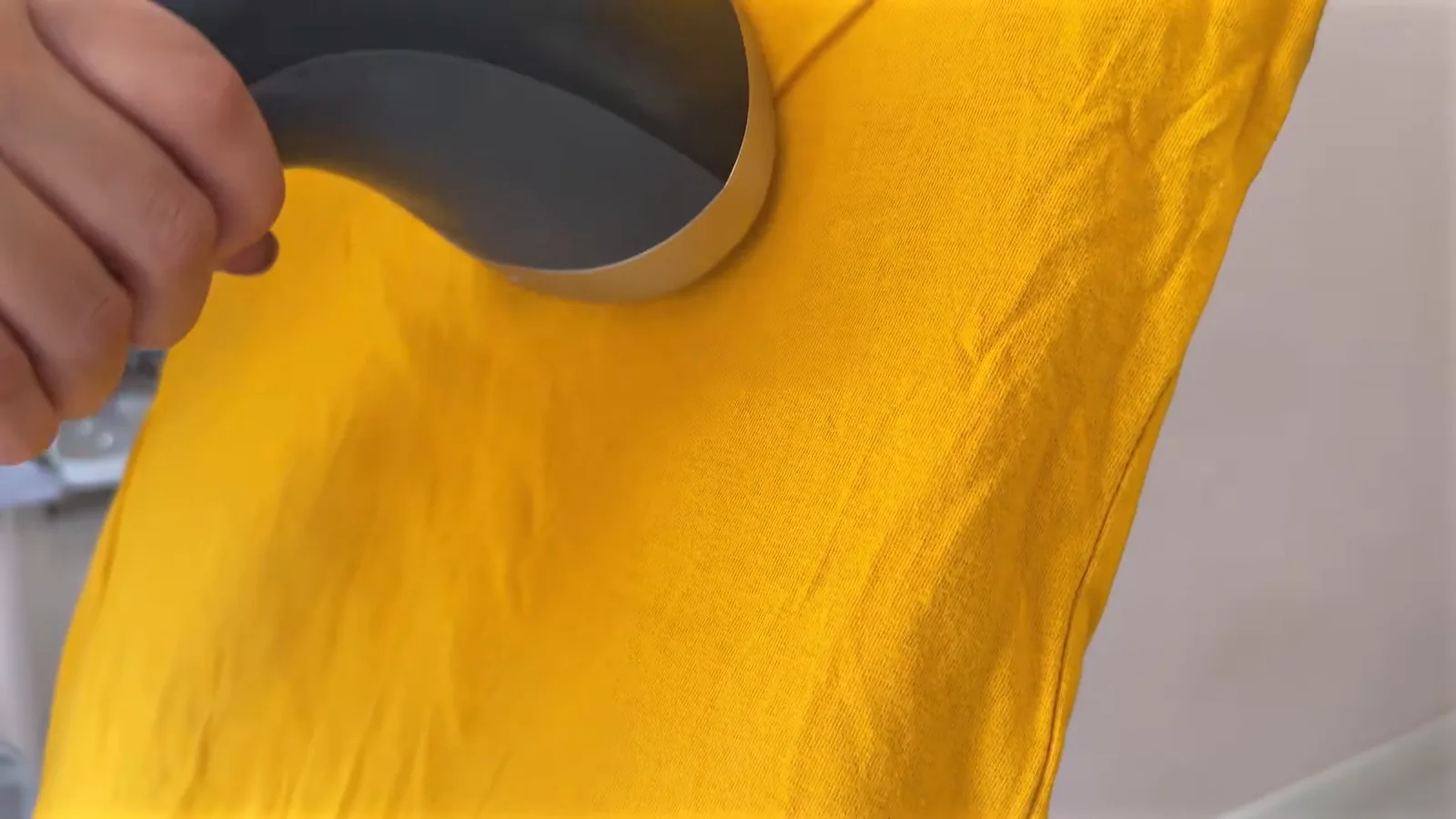 Bocal a vapor alisando camiseta de algodão na prancha vertical