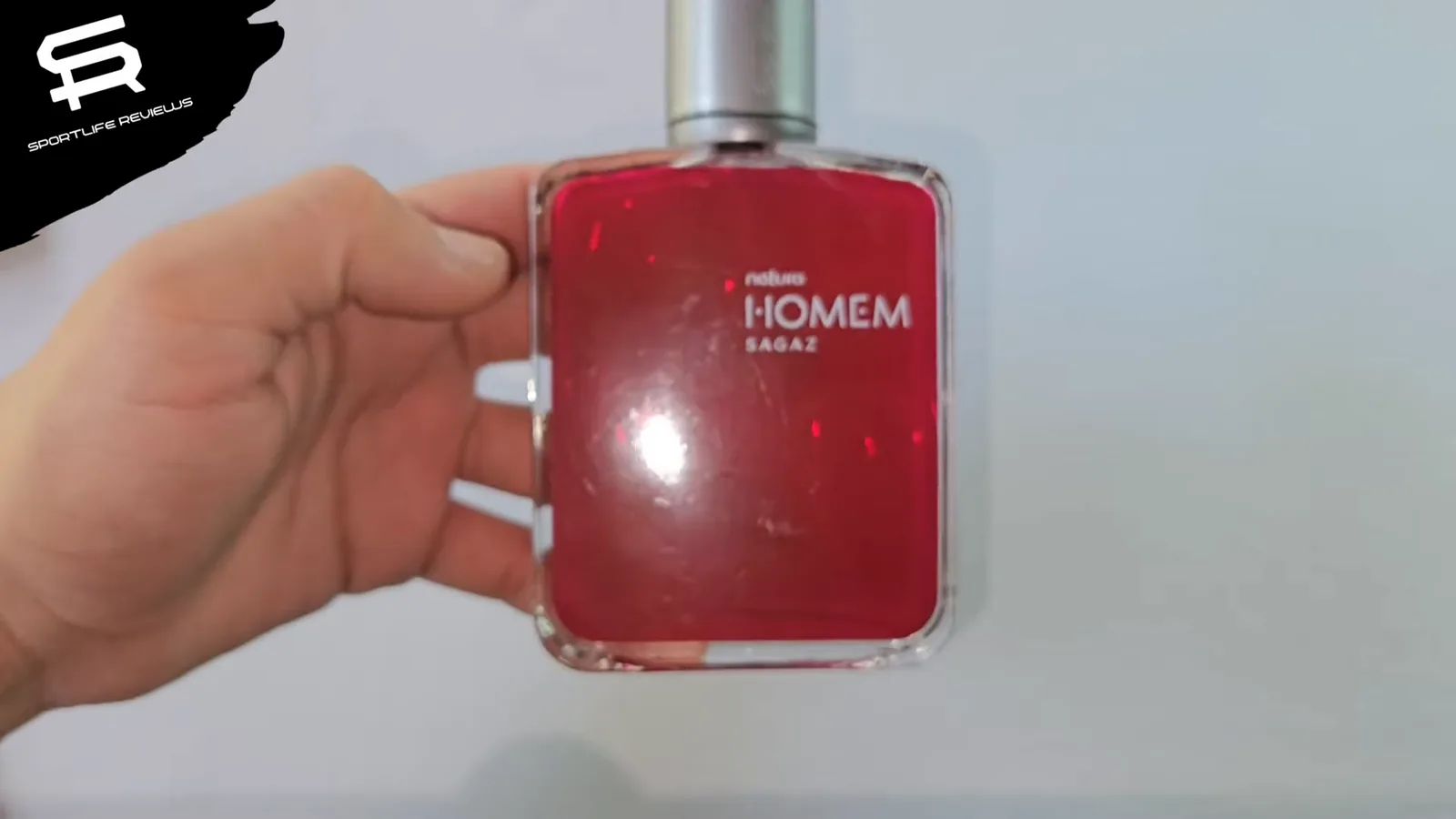 Frasco de vidro do perfume masculino Natura Homem Sagaz em mãos