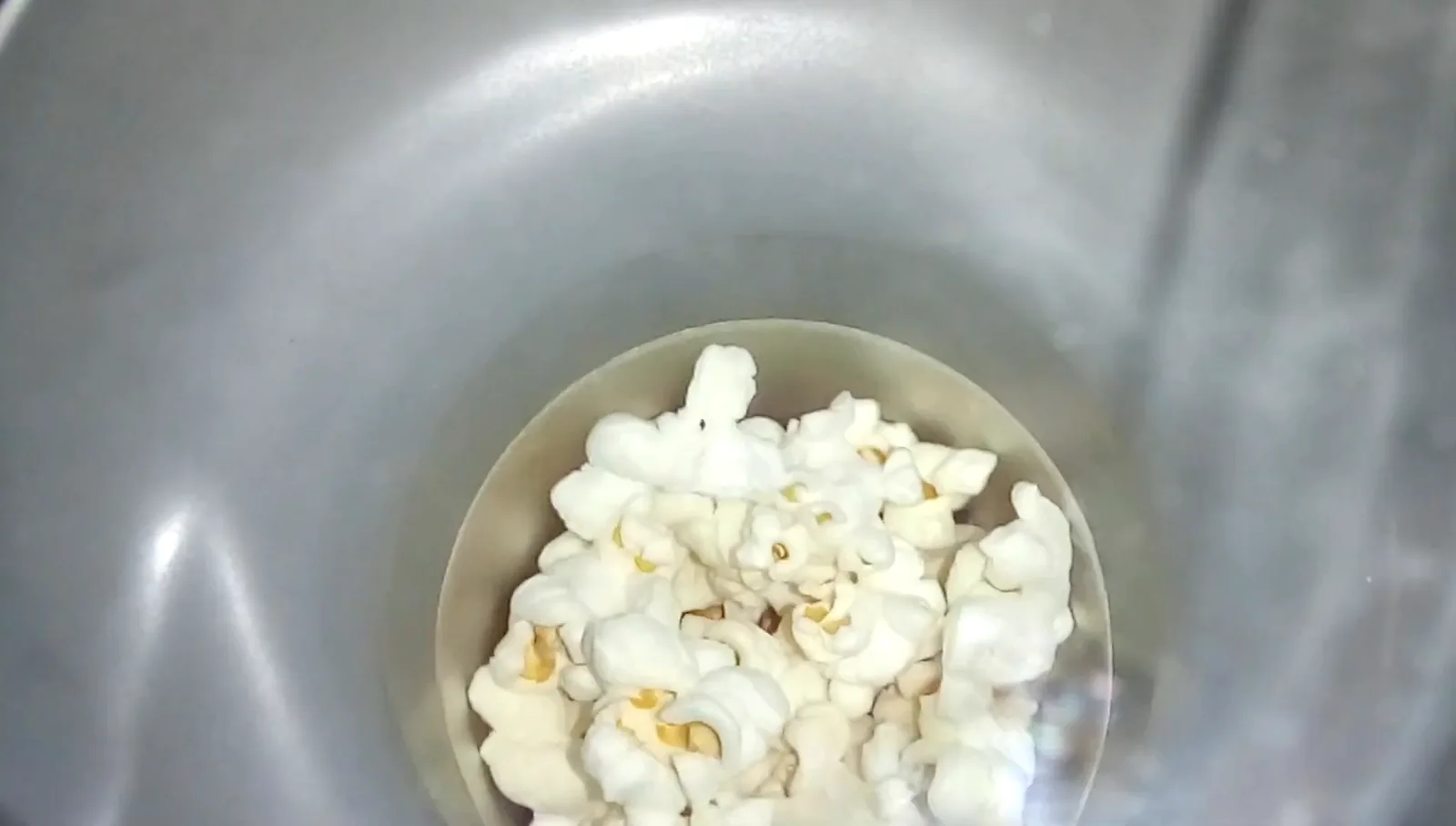 Grãos de milho estourando dentro da câmara térmica da pipoqueira Britânia