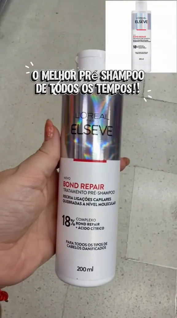 Frasco do tratamento pré-shampoo Elseve Bond Repair segurado na mão