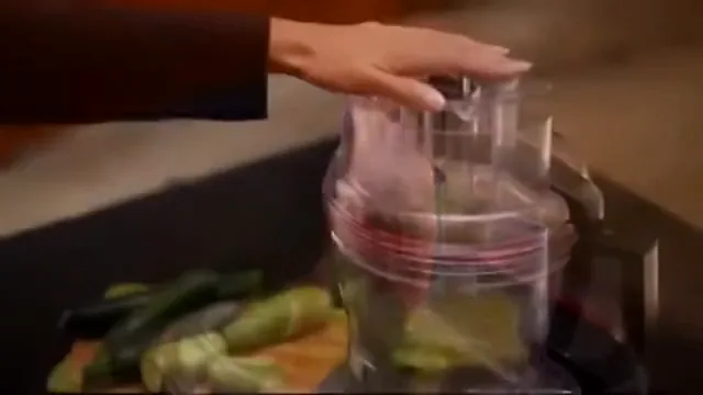Processador KitchenAid fatiando abobrinhas através do bocal de alimentação