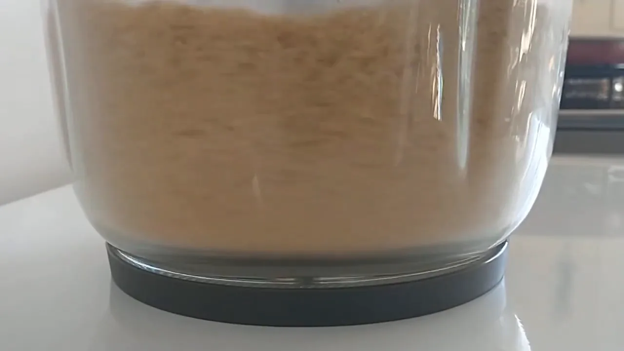 Miniprocessador triturando amendoim dentro da tigela de vidro