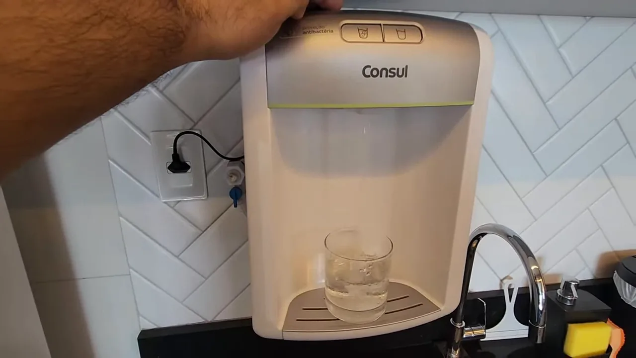 Purificador Consul dispensando água no copo com fluxo contínuo
