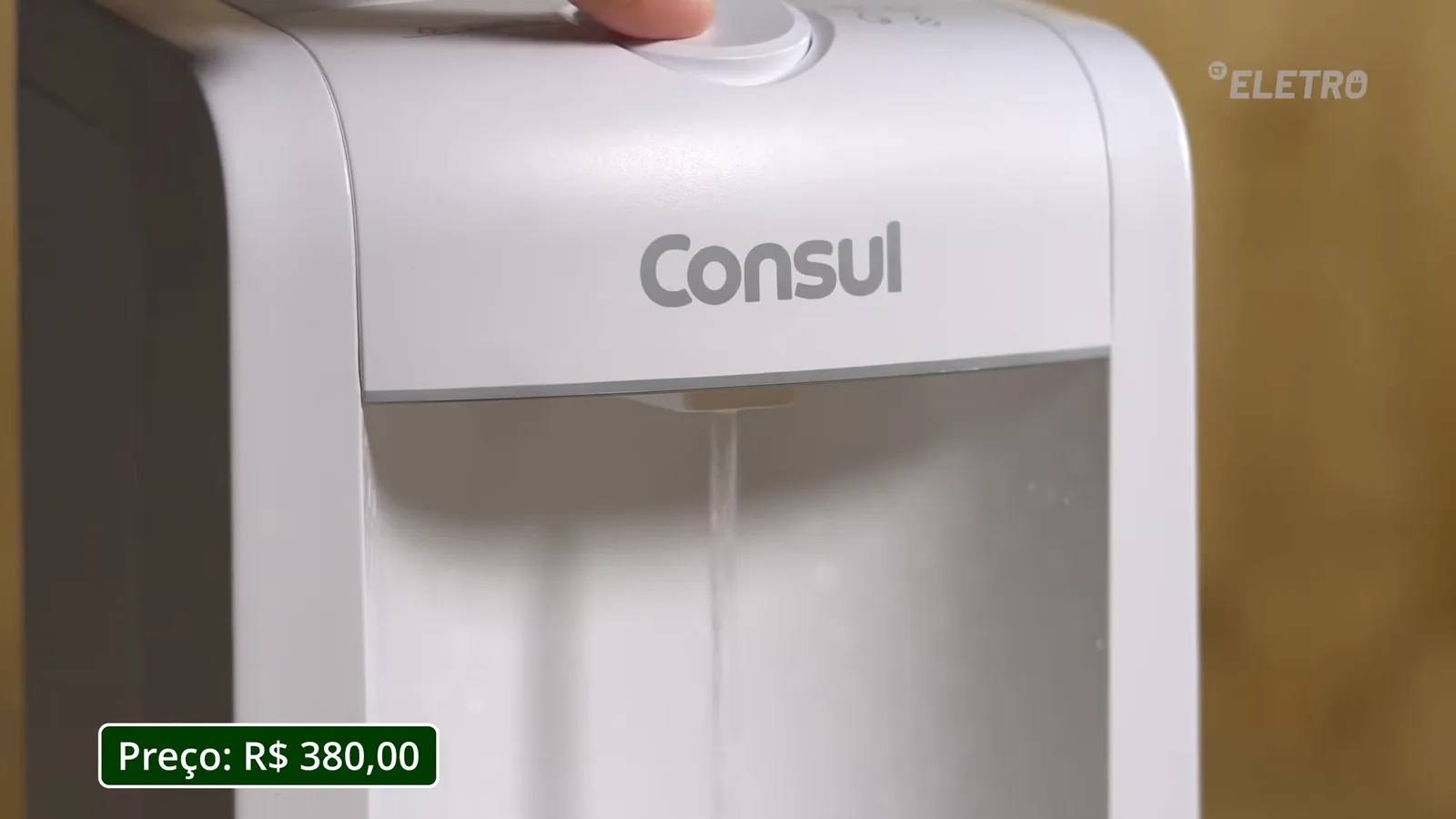 Mão pressionando botão superior para liberar água filtrada no copo