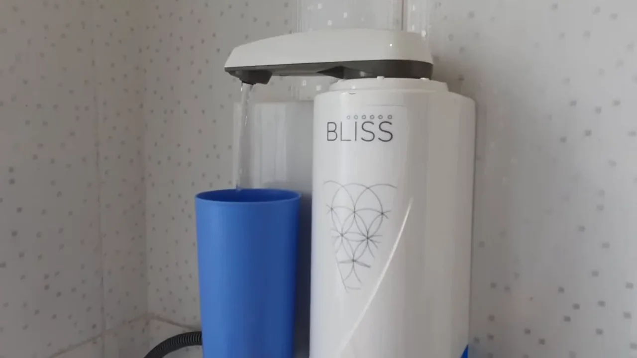 Purificador Europa Bliss acionado vertendo água diretamente no copo