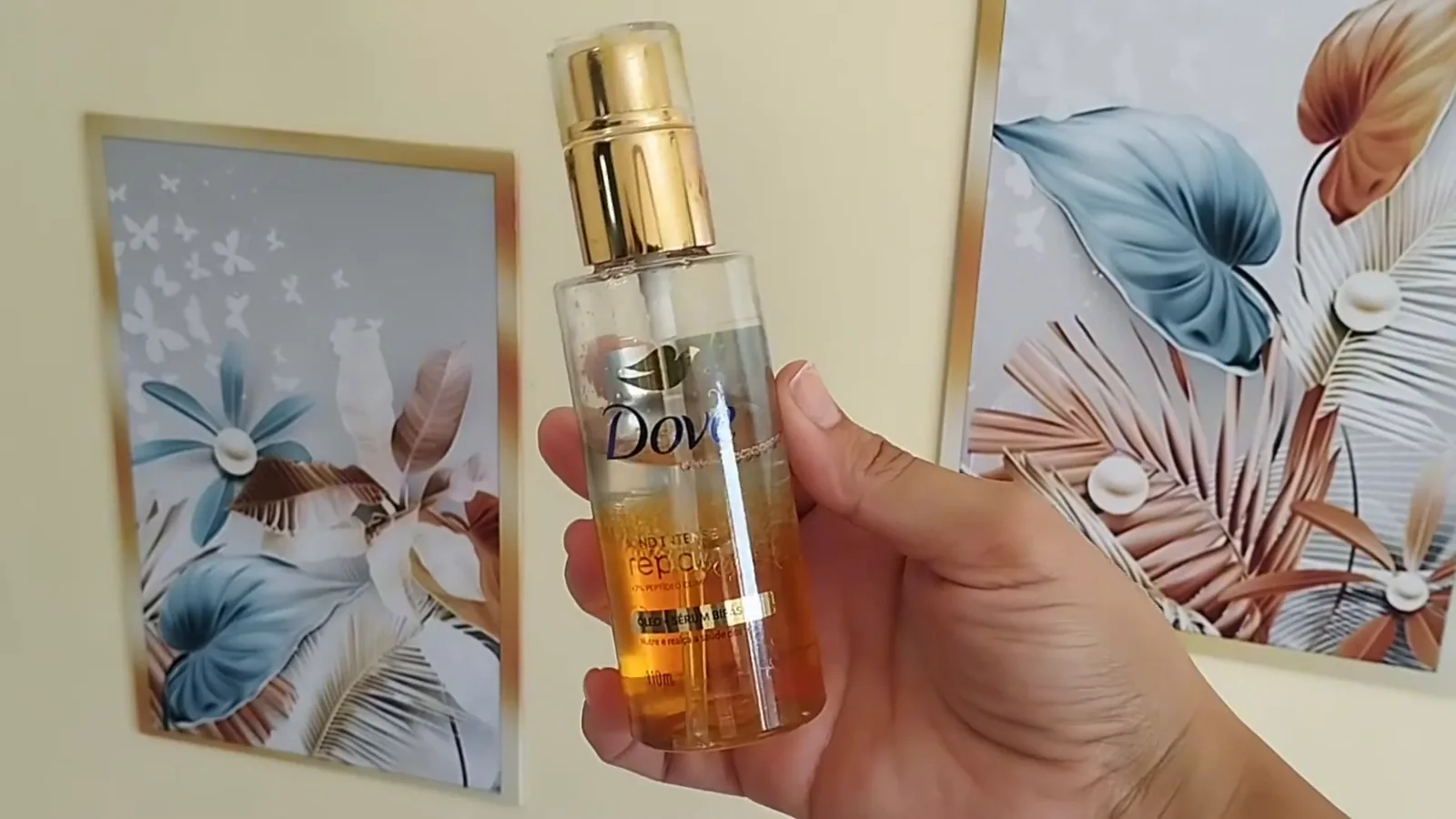 Óleo bifásico Dove Bond Intense Repair seguro pela mão em primeiro plano