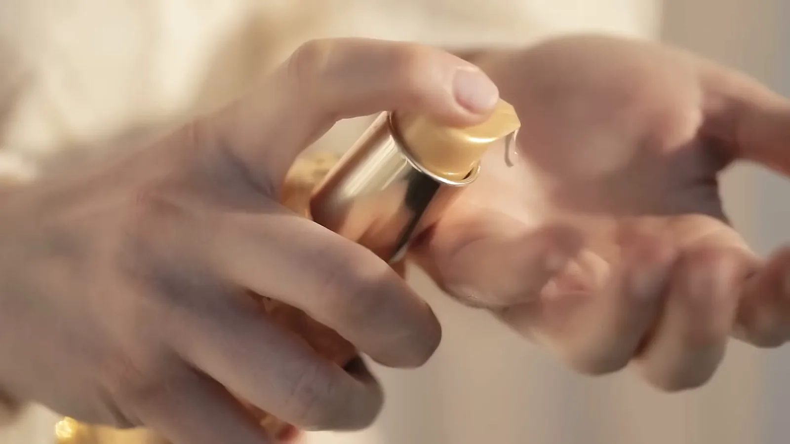 Aplicação do óleo Kérastase Elixir Ultime pressionando a válvula dosadora