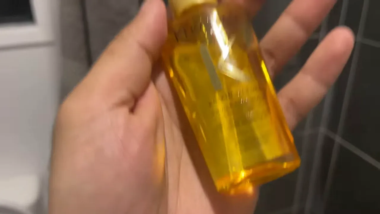 Apresentação do frasco de Kérastase Elixir Ultime manuseado na mão