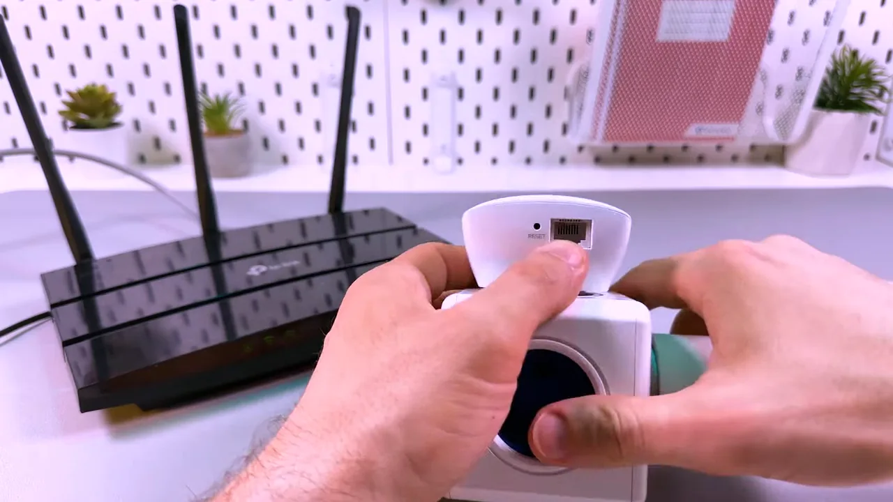 Repetidor ligado sendo manuseado para demonstrar a porta Ethernet inferior
