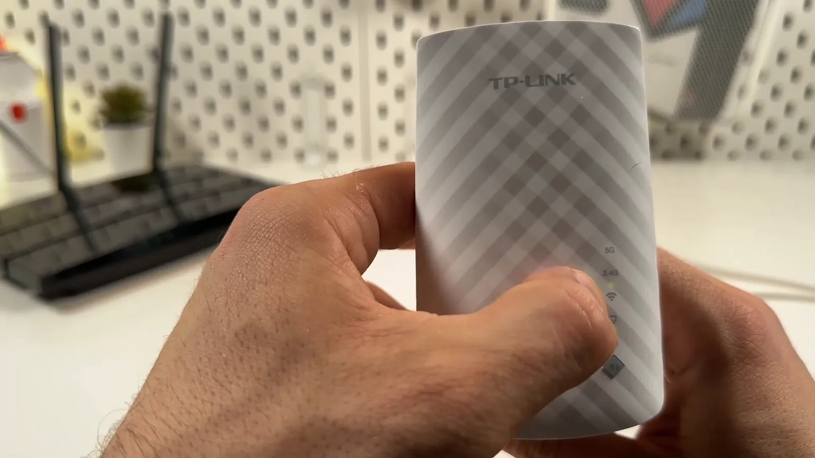 Repetidor TP-Link RE200 ligado exibindo luzes indicadoras na carcaça frontal