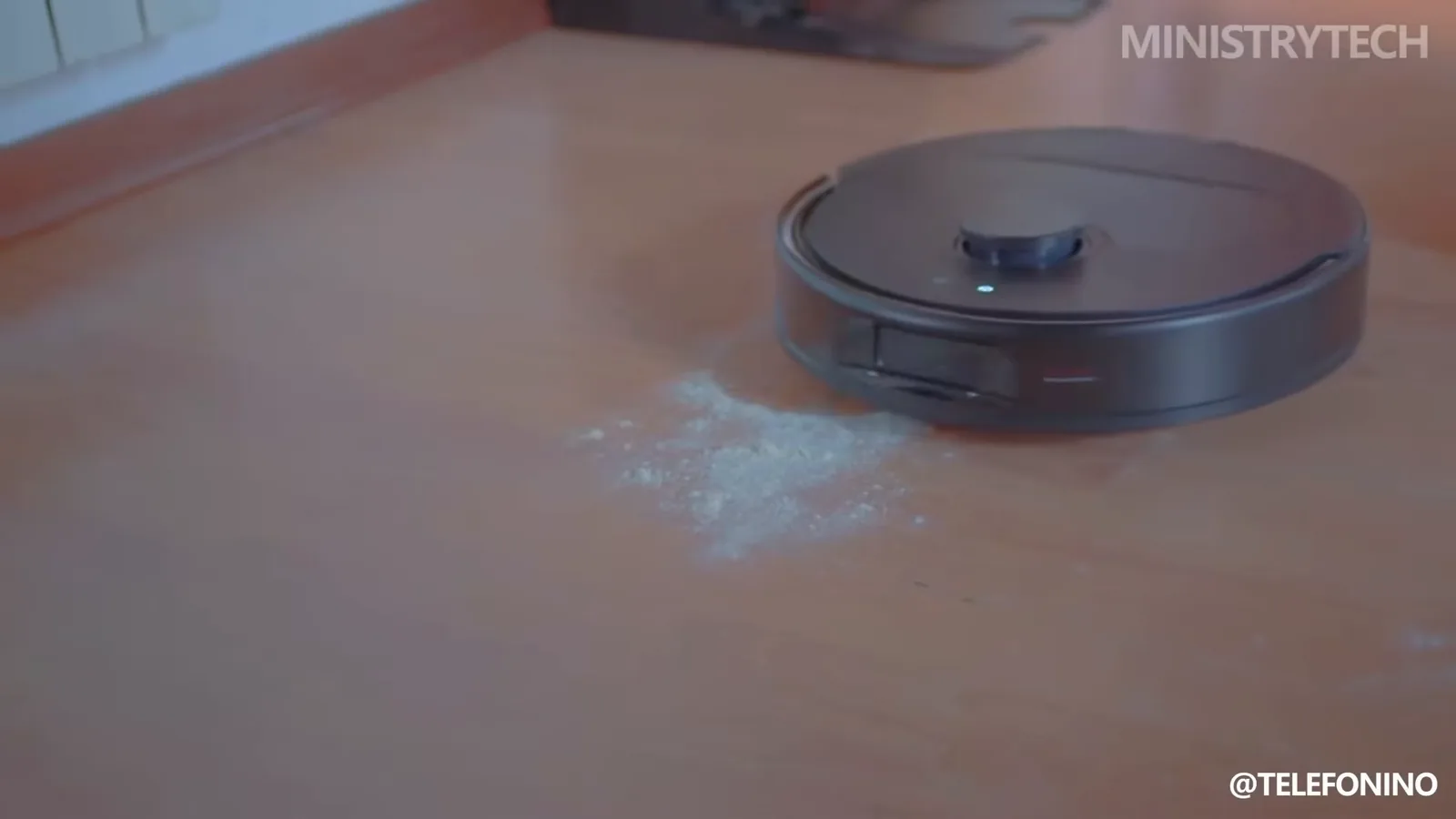 Robô aspirador Roborock preto aspirando pó sobre superfície de madeira
