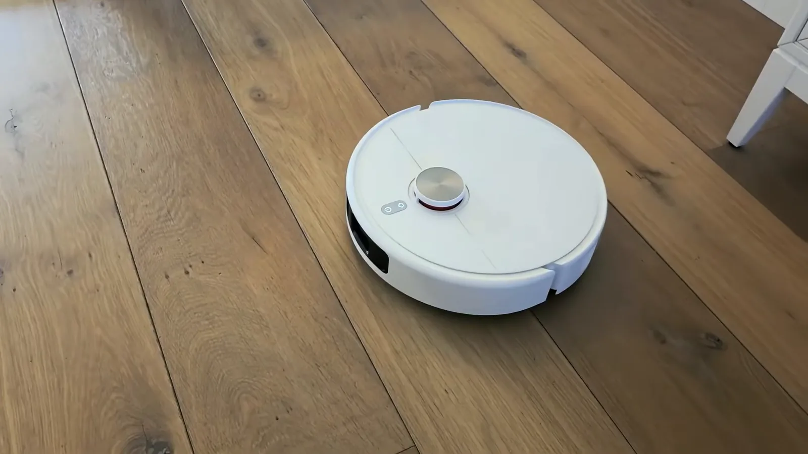 Aspirador robô navegando pelo chão de madeira da sala