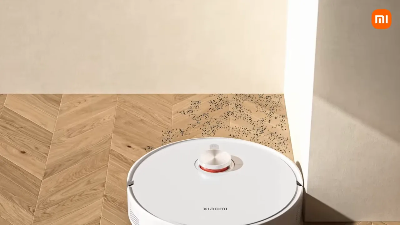 Robô aspirador Xiaomi limpando detritos rente à parede sobre piso laminado