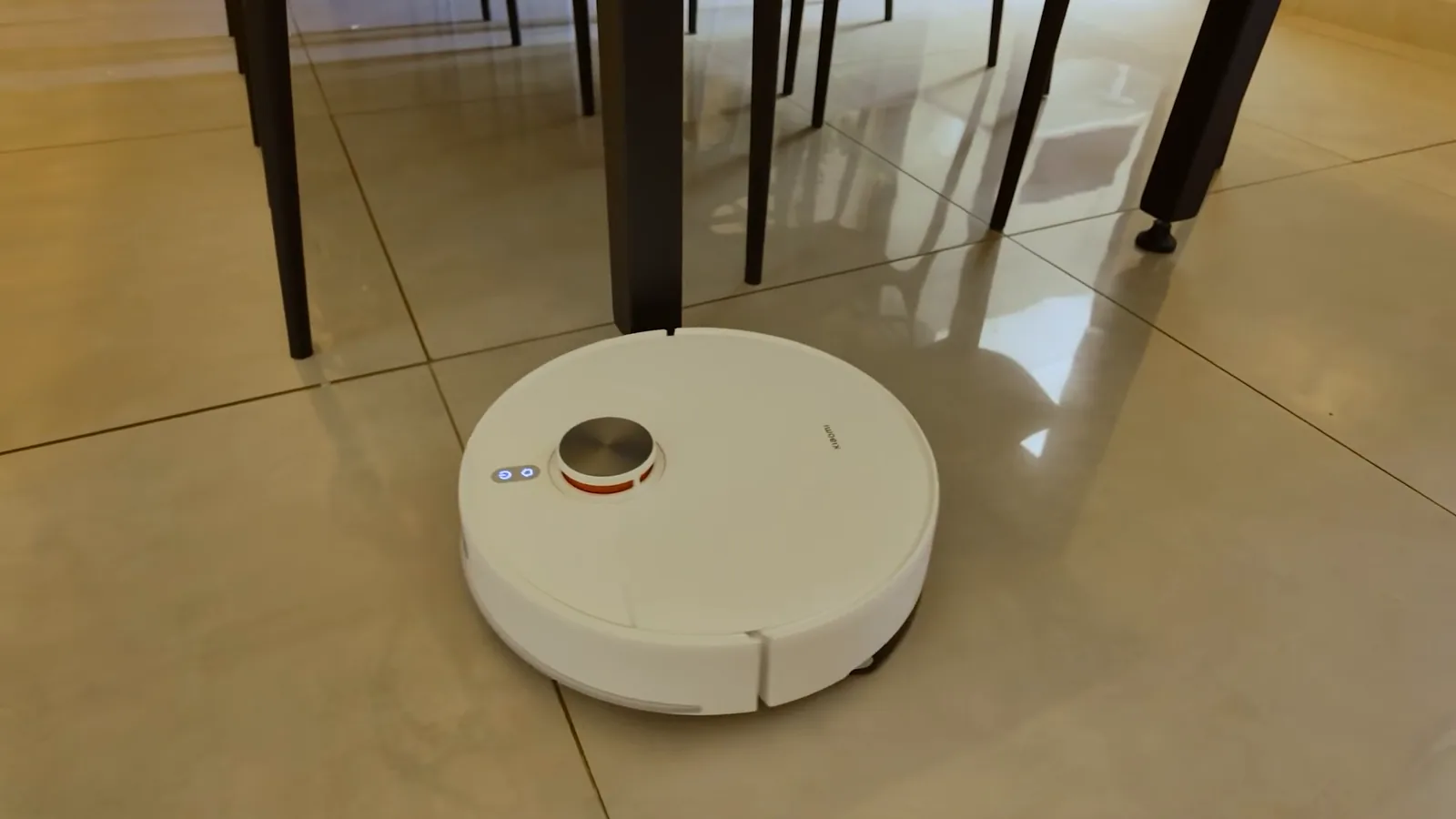 Robô aspirador S40 navegando entre pés de cadeiras e mesa