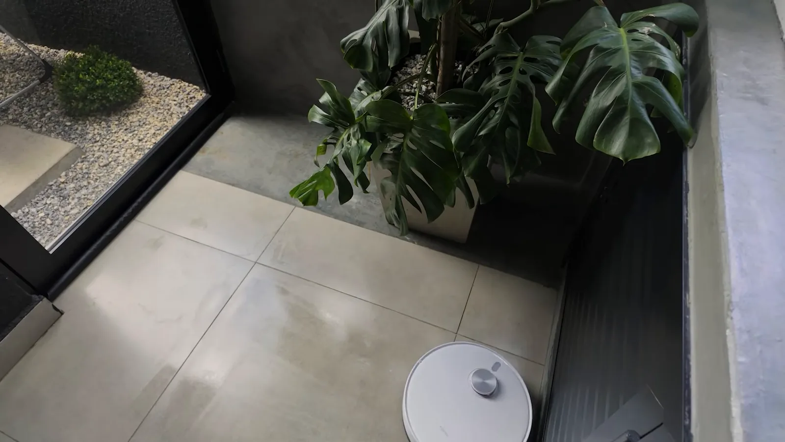 Robô Xiaomi S40 aspirando piso frio ao lado de vaso