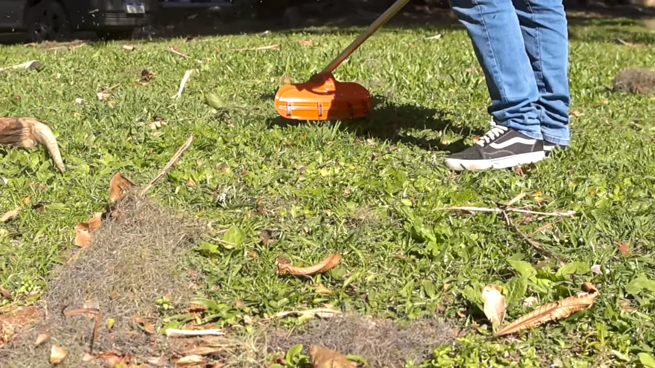 Roçadeira a gasolina sendo utilizada no corte do gramado