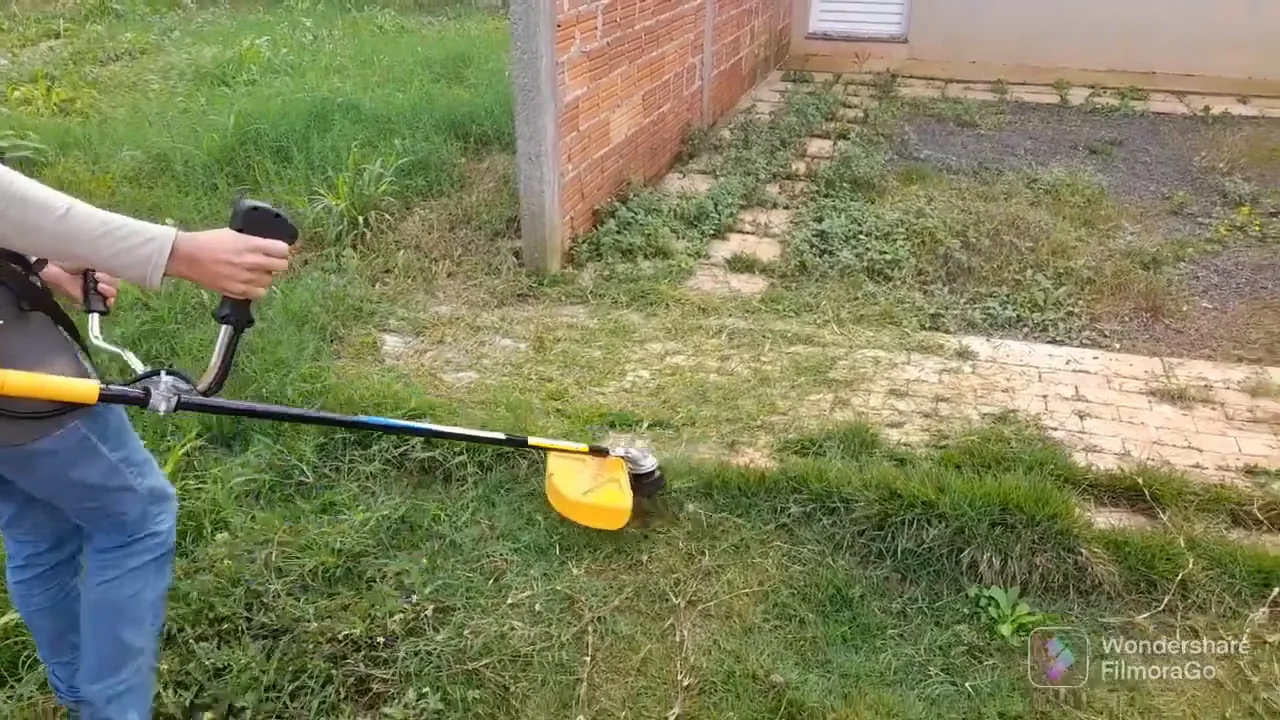 Roçadeira cortando grama no meio-fio com carretel de nylon
