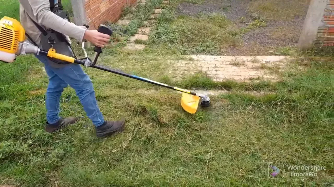 Aparando vegetação na calçada com roçadeira a gasolina potente