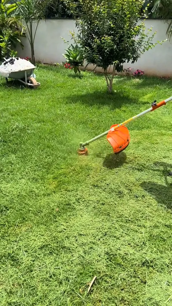 Roçadeira Nakasaki aparando a grama do jardim com carretel de nylon