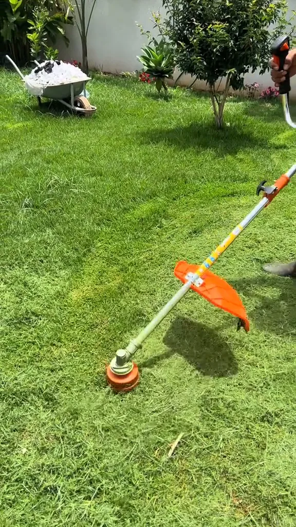 Roçadeira a gasolina cortando o gramado em movimento contínuo