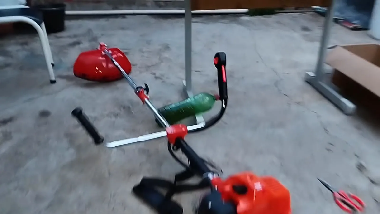 Roçadeira a gasolina Nakasaki funcionando no chão durante o primeiro teste
