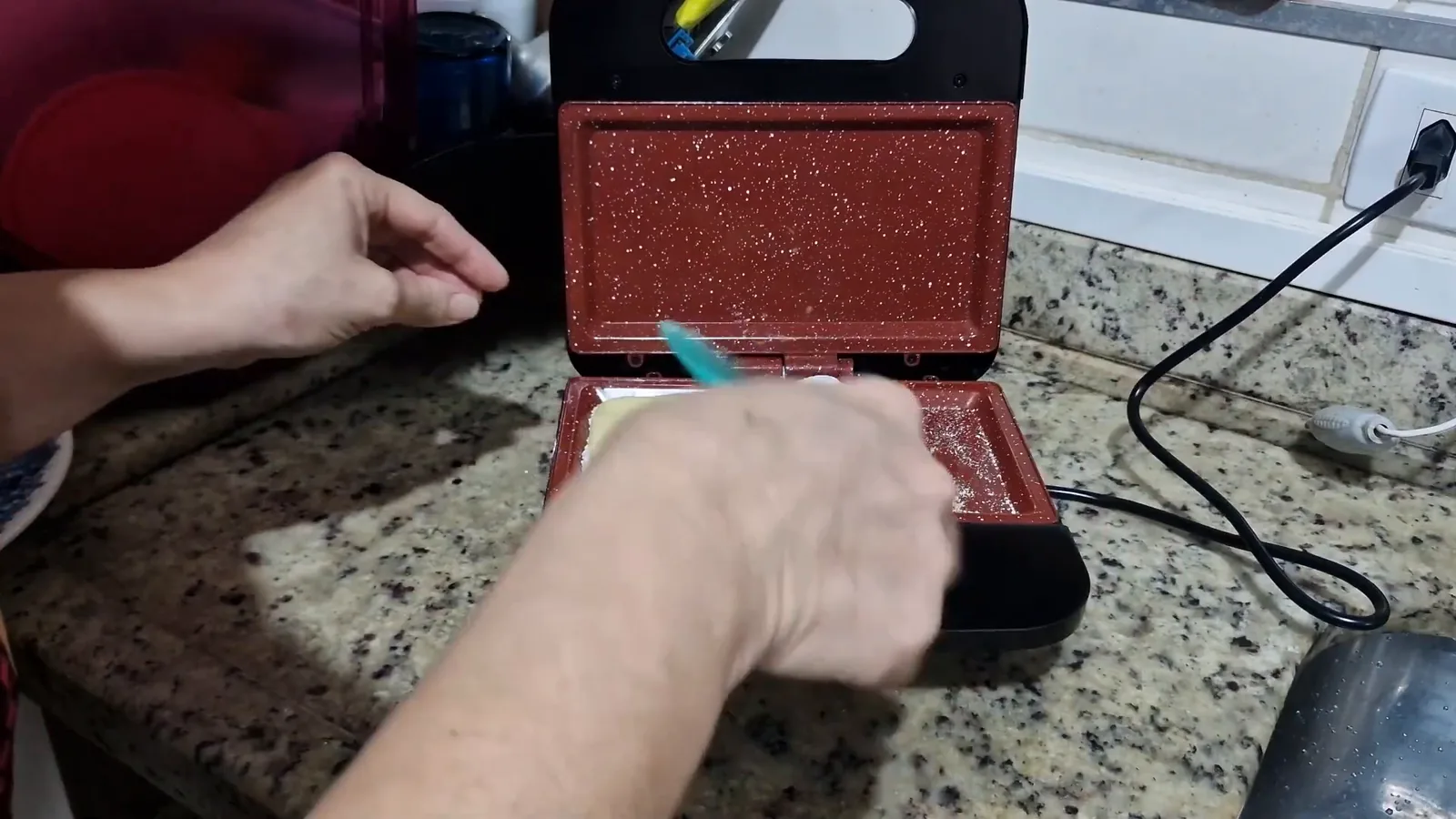 Dobrando a tapioca com presunto e queijo na chapa aquecida