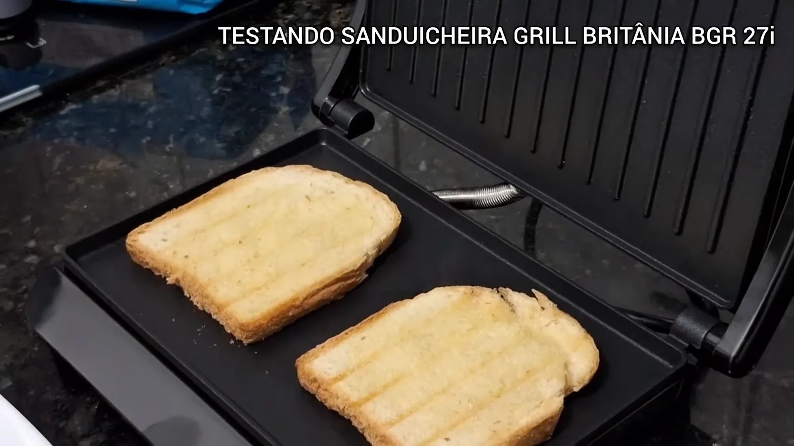 Sanduicheira aberta tostando fatias de pão de forma na chapa