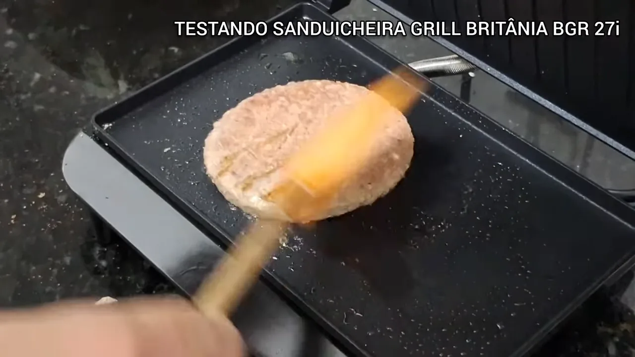 Abertura da tampa articulada e virada do hambúrguer na chapa