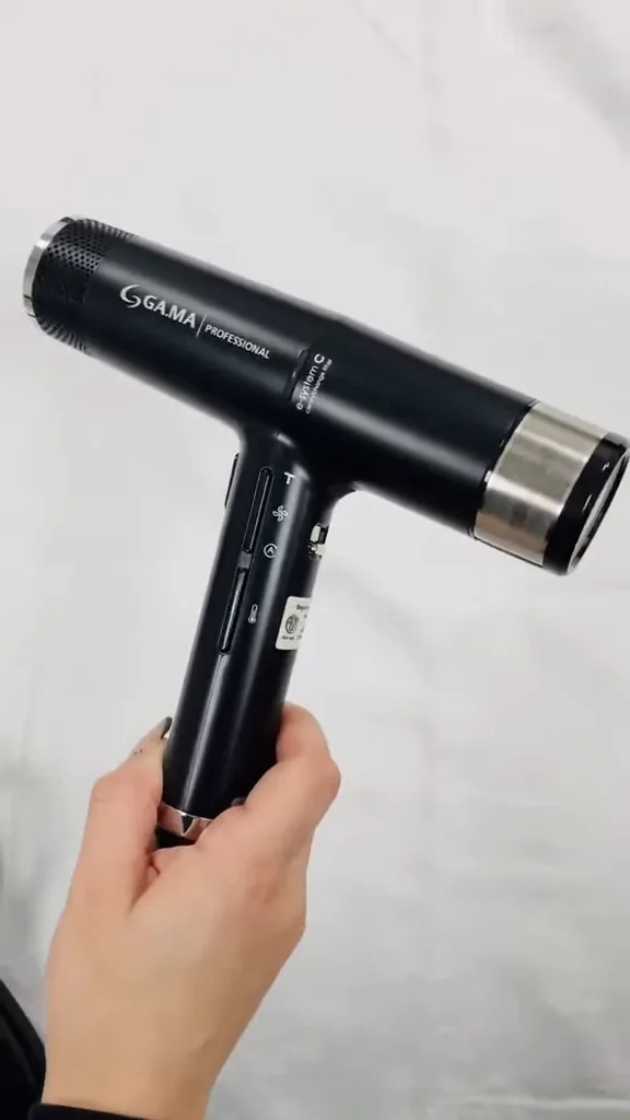 Manuseio do secador GA.MA Italy iQ3 destacando o corpo ultraleve e botões