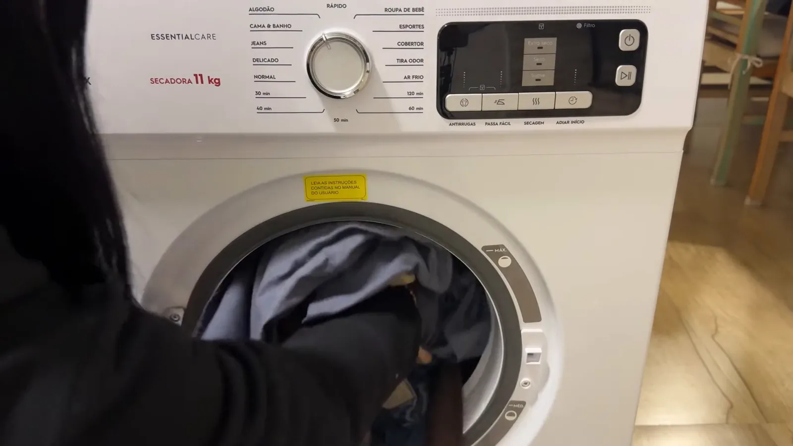 Colocando roupas no tambor da secadora Electrolux Essential Care STL11